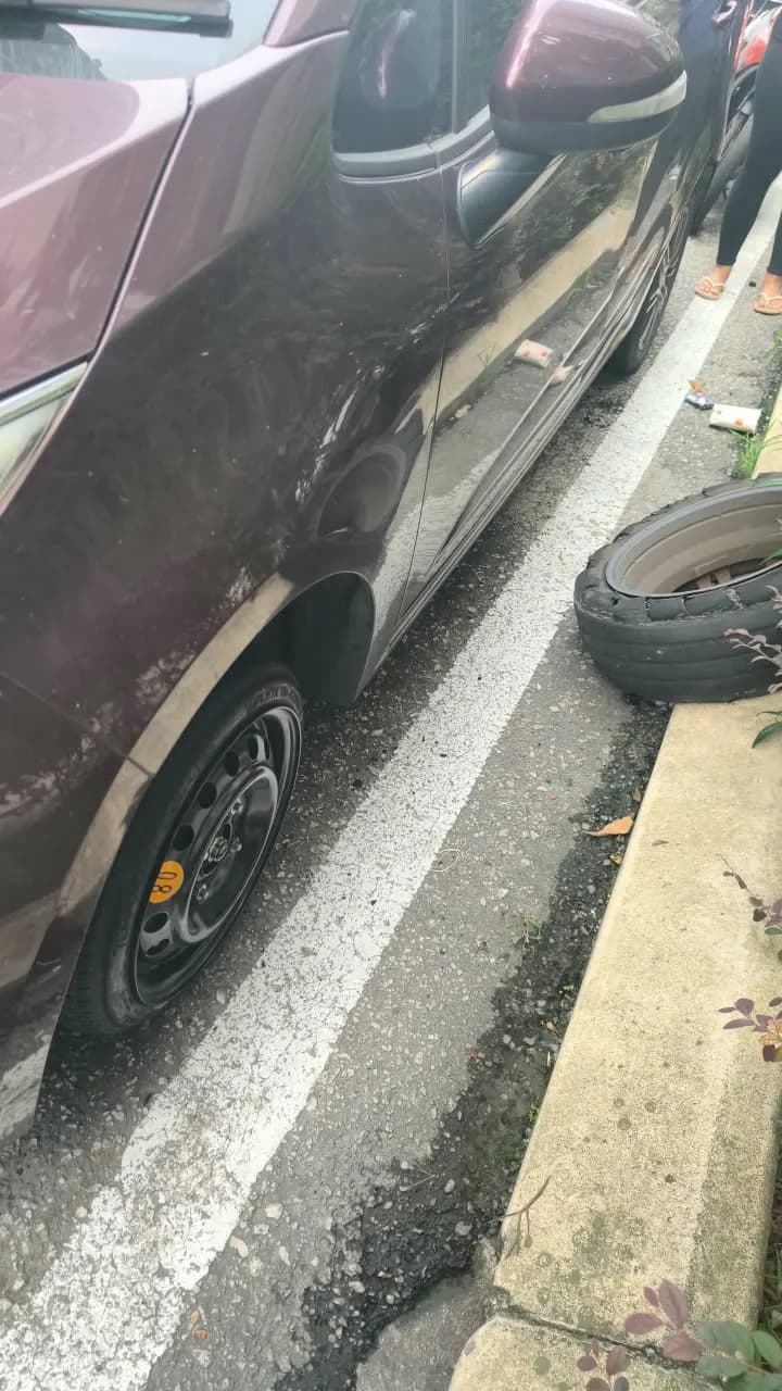 Spare tyre fitted at the roadside, burst tyre set aside